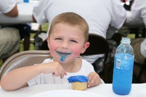Young Boy Eating Cupcake w/ Blue Icing